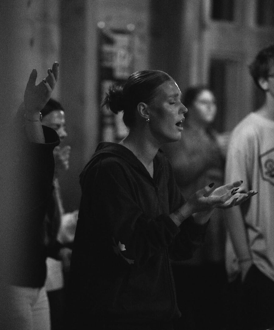 Black and white photo of a woman worshiping with eyes closed and hands open
