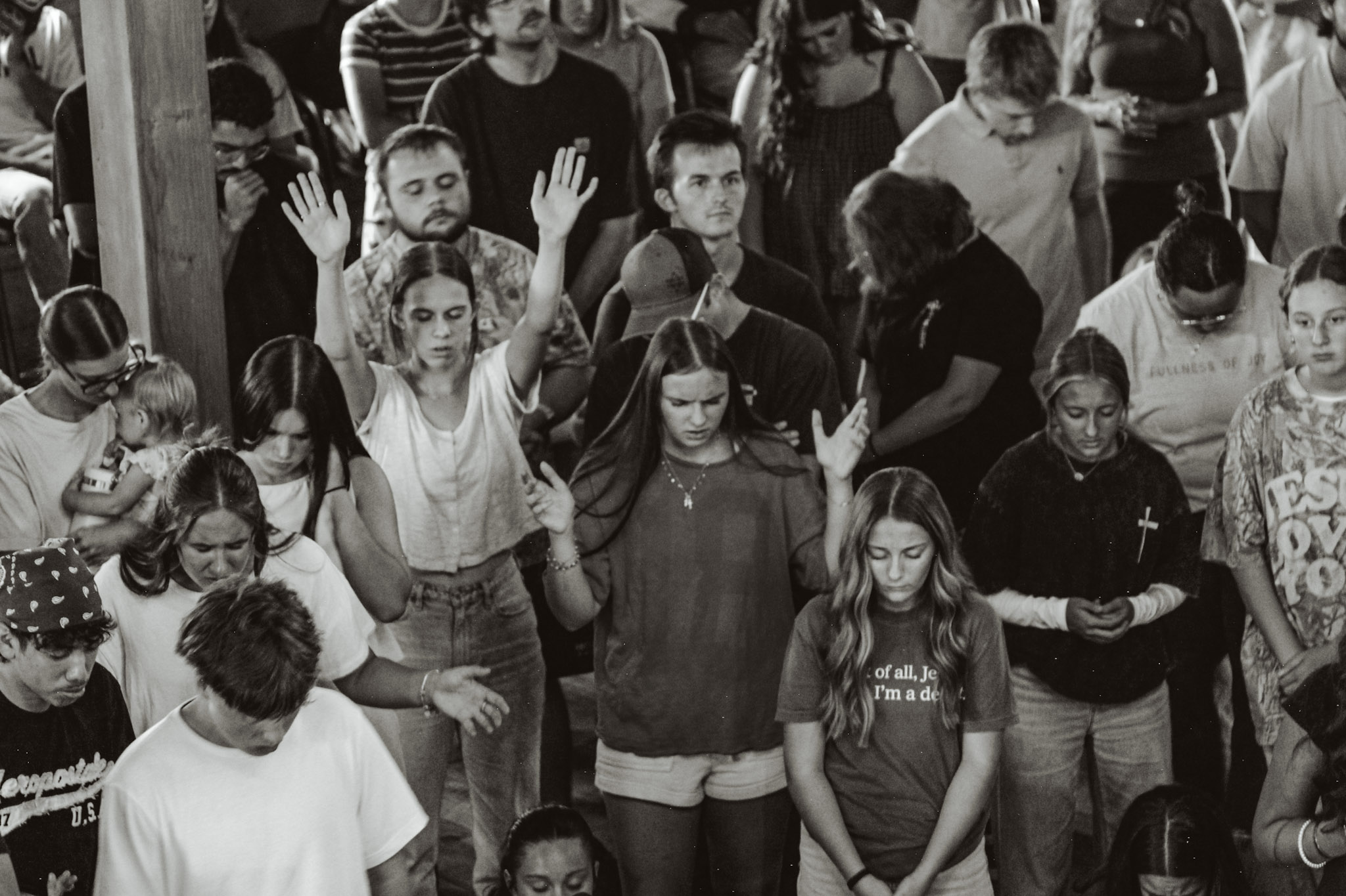 Our community in worship and prayer, hands raised and heads bowed
